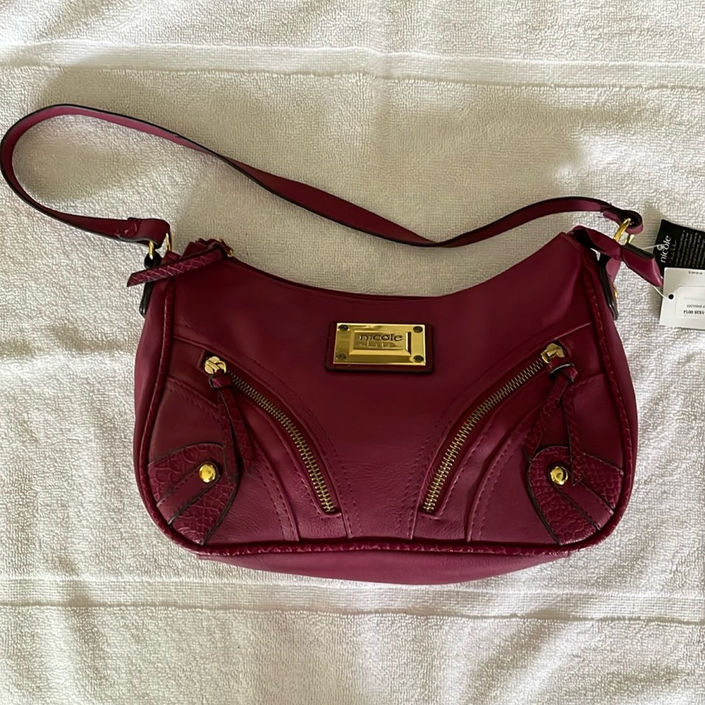 New (with tags) Nicole maroon purse. It has 2 cute zippered pockets on the front